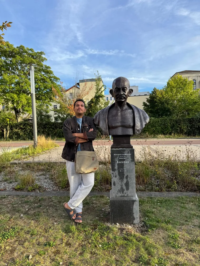 P. K. Tiwari beside a bust of Mahatma Gandhi